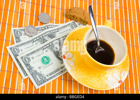 Tre dollari e 50 cent pagare per caffè e biscotti sul bambù panno della tabella Foto Stock