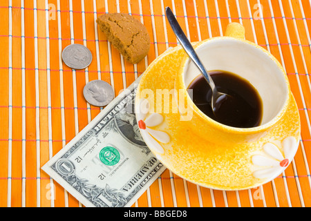 Tre dollari e 50 cent pagare per caffè e biscotti sul bambù panno della tabella Foto Stock