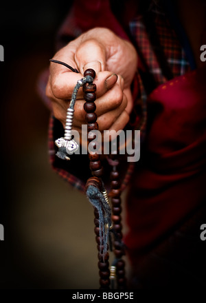 Close-up del vecchio monaco tenendo un rosario - Bhutan Foto Stock