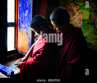 Due giovani monaci bhutanesi riproduzione di marmi - Punakha Dzong, Bhutan Foto Stock