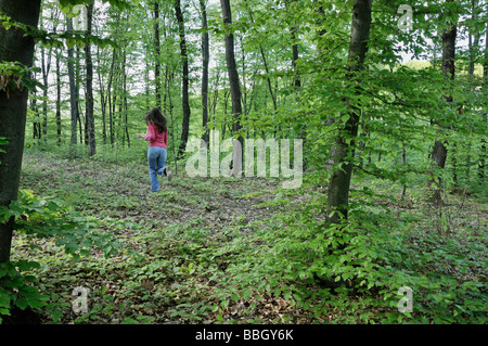 Giovane donna in esecuzione nei boschi Foto Stock