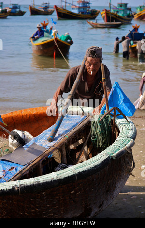 Il vietnamita fisher spingendo la sua piccola barca Foto Stock