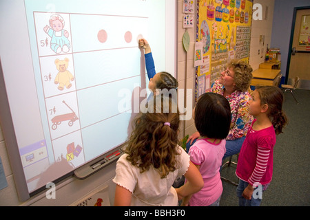 Kindergarten agli studenti di utilizzare una lavagna interattiva in aula di una scuola pubblica a Boise Idaho USA MR Foto Stock