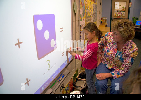 Kindergarten agli studenti di utilizzare una lavagna interattiva in aula di una scuola pubblica a Boise Idaho USA MR Foto Stock