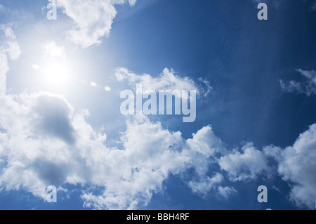 Guardando il sole durante il giorno contro un blu e il cielo nuvoloso Foto Stock