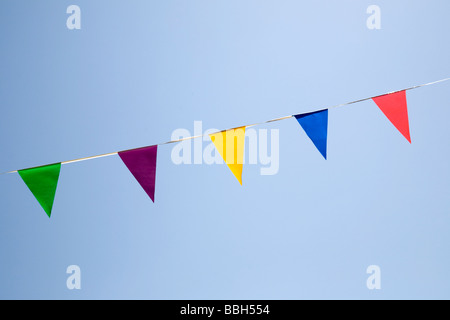 Bunting - Bandiere triangolari di diversi colori contro un cielo blu Foto Stock