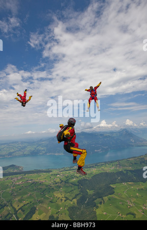 Skydivers sono battenti con testa in alto e in basso su una montagna spettacolare / paesaggio lacustre con oltre 150 mph velocità. Per il divertimento di tutti. Foto Stock