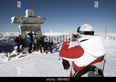 Gruppo di sciatori di loro fotografia scattata nella parte anteriore del Inukshuk sulla Whistler montagna simbolo del 2010 giochi olimpici Foto Stock