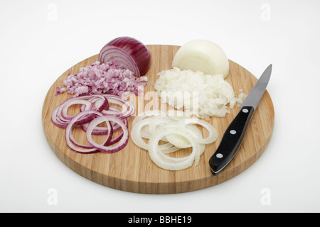 Bianco e le cipolle rosse (Allium cepa), sbucciato le cipolle a dadini, anelli di cipolla su una tavola di legno con un coltello Foto Stock