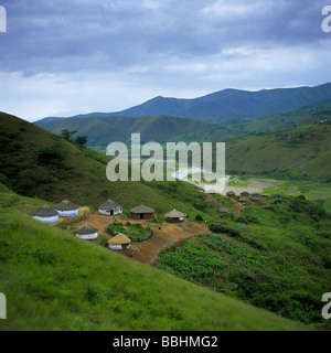 Immerso nel verde delle colline di ZULULAND VICINO A ESHOWE ZULU persone che ancora vivono in case tradizionali e osservare la dogana di Foto Stock