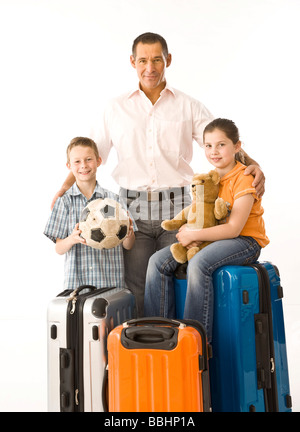 Padre di due figli, circondato da valigie Foto Stock