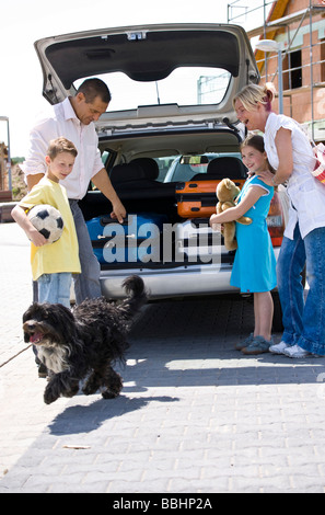 Famiglia stivare le valigie in auto Foto Stock