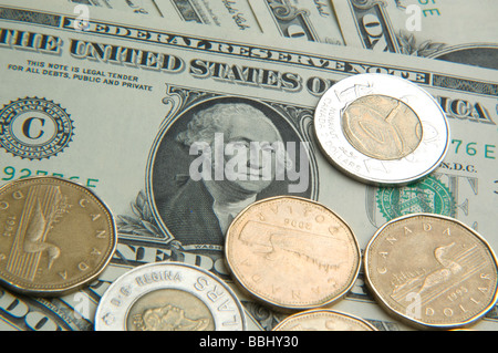 Dollaro americano Bill circondato dal canadese uno e due monete del dollaro Foto Stock