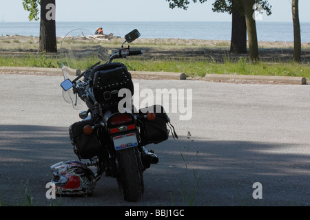 Giovane coppia seduta sulla riva di un lago Erie nel parco cittadino viaggio attivo vista posteriore dei grandi Laghi in Ohio Stati Uniti alta risoluzione orizzontale degli Stati Uniti Foto Stock