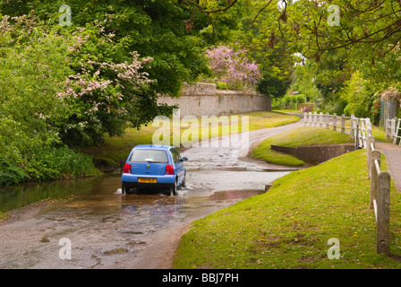Un car guida attraverso una Ford in esecuzione in un vicolo del paese nella campagna del Regno Unito Foto Stock