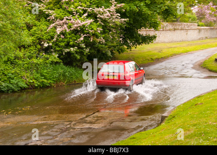 Un car guida attraverso una Ford in esecuzione in un vicolo del paese nella campagna del Regno Unito Foto Stock