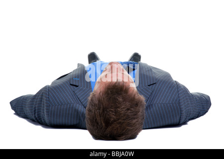 Imprenditore della tuta e tirante giacente sulla sua schiena visto dalla sua testa a basso angolo isolato su uno sfondo bianco Foto Stock