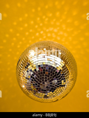 Palla da discoteca appeso ad un soffitto di colore giallo Foto Stock