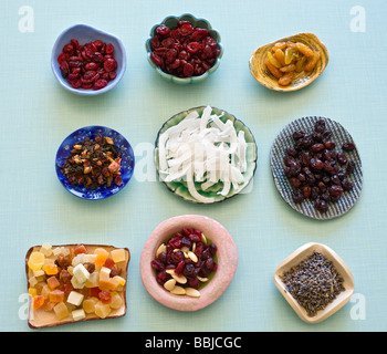 Un assortimento di frutta secca tagliata a quadrati per la stagionatura in un quadrato vaso in ceramica su sfondo rétro Foto Stock