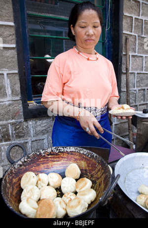 Donna tibetana momos di frittura. McLeod Ganj. Dharamsala. Himachal Pradesh. India Foto Stock