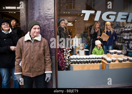 Guardare la gente come manifestanti marzo giù Laugavegur. Il centro di Reykjavik Islanda Foto Stock