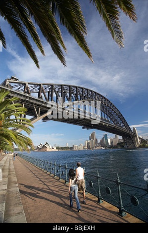 Giovane a piedi dal Ponte del Porto di Sydney Opera House di Sydney e il CBD Sydney New South Wales AUSTRALIA Foto Stock