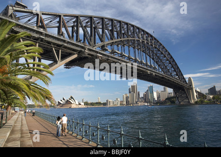 Giovane a piedi dal Ponte del Porto di Sydney Opera House di Sydney e il CBD Sydney New South Wales AUSTRALIA Foto Stock