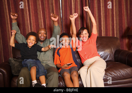 Famiglia di guardare la televisione e rasserenanti Foto Stock