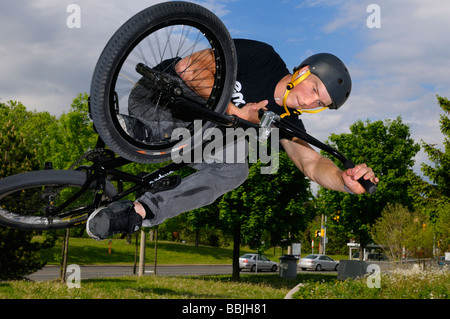 Airborne urban bmx bike rider in un aria fuori dal piano portapaziente oltre il traffico locale a Toronto city skatepark Foto Stock