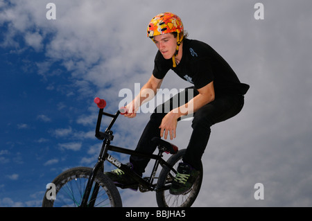 BMX bike rider con casco volare in aria contro un cielo blu con nuvole di Toronto in Canada Foto Stock