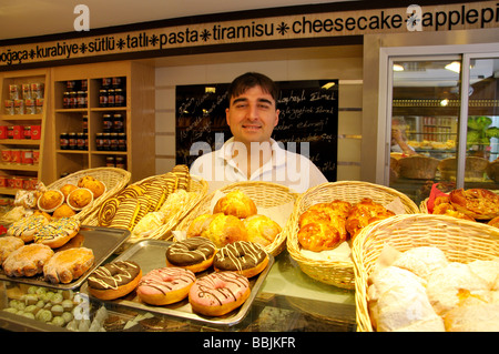 Proprietario dietro il banco della pasticceria turca, Old Bazaar, Bodrum, Penisola di Bodrum, Provincia di Mugla, Repubblica di Türkiye Foto Stock