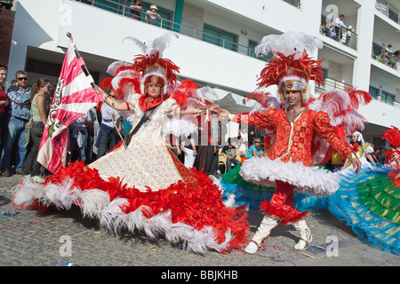 "Porta Bandeira" e "Mestre Sala" caratteri, che esibisce la bandiera di una scuola brasiliana di samba, in Sesimbra Carnevale (Portogallo) Foto Stock