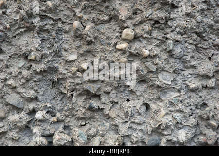 Sfondo dalla consistenza del muro di cemento con piccoli sassi Foto Stock