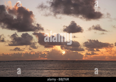 Sole che splende attraverso le nuvole scure al tramonto oltre Oceano Pacifico del Sud Rarotonga Isole Cook Polinesia Foto Stock