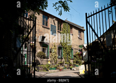 Vista attraverso i cancelli del principale edificio in mattoni a Hackney City Farm in East London, Regno Unito Foto Stock