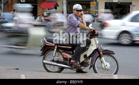 Risposta a una mobile su una moto in Ho Chi Minh City Vietnam sullo sfondo di ora di punta del traffico. Foto Stock