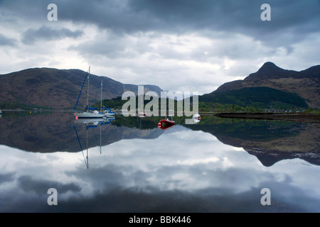 Barche a vela riflettendo in Loch Leven, Glencoe, Ballachulish, Scozia. Foto Stock