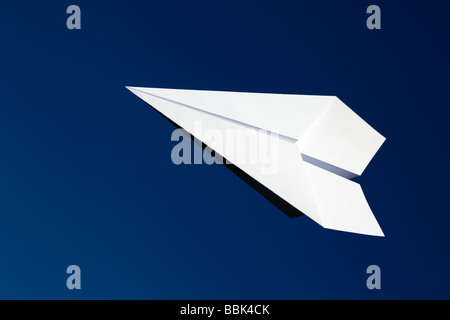Aeroplano di carta flying contro un cielo blu Foto Stock