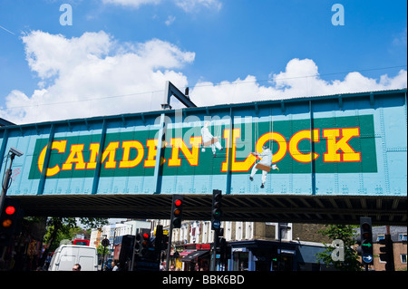 Camden Lock Village market , iconico punto di riferimento ponte ferroviario con divertente lato verniciato & luci rosse & traffico Foto Stock