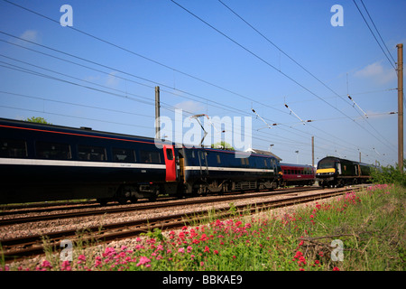 158806 East Midlands 43065 Grand Central e a 91 Classe National Express che passa a Helpston passaggio a livello 29 05 2009 Foto Stock