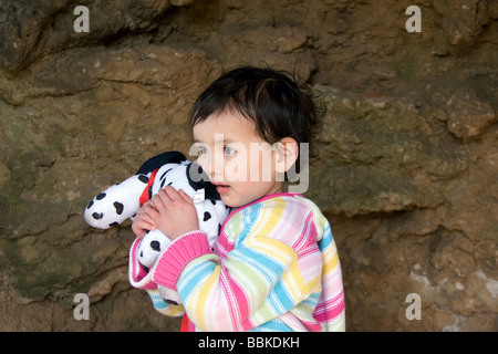 Un giovane semi-Thai girl coccola la Sua soffice, macchie cane giocattolo sotto un uomo arco di roccia a Skegness promenade, Lincolnshire Foto Stock