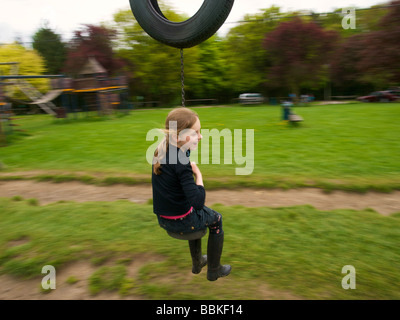 Ragazza 8 anni avendo divertimento a giocare nel parco giochi Oteppe Belgio sfocatura del movimento Foto Stock