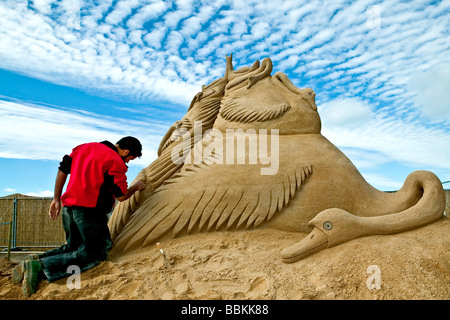 L'uomo creando una scultura di sabbia Foto Stock