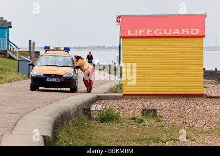 Un bagnino colloqui per una guardia costiera sulla spiaggia Tankerton Whitstable Kent REGNO UNITO Foto Stock