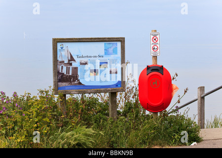 Un segnale di informazione sui pendii Tankerton accanto a un cane bin e cartelli di avvertimento Thames per centrali eoliche in sfondo nebuloso Whitstable REGNO UNITO Foto Stock