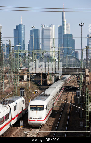 Un ICE Intercity-Express treno ad alta velocità è di lasciare la stazione ferroviaria principale, nel retro della skyline di Francoforte con il Commerzban Foto Stock