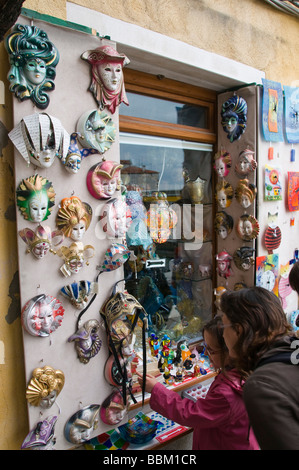 I turisti alla ricerca di maschere viso al di fuori di un negozio di souvenirs vetro Murano Venezia Italia Foto Stock