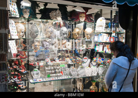 Per turisti in cerca di maschere viso sul display nella finestra del negozio Murano Venezia Italia Foto Stock