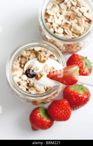 Muesli con yogurt e fragole in piccoli vasetti di vetro Foto Stock