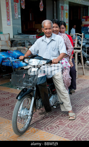 Famiglia di tre persone su una moto di Battambang, Cambogia Foto Stock